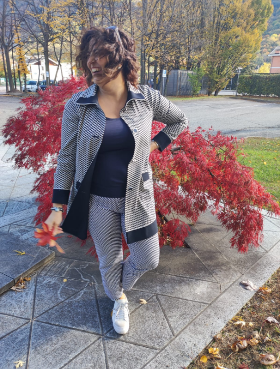 Photo of Raffaela Marescalco, a professional Feng Shui consultant, in front of a plant with reddish leaves. Her Feng Shui consultations will change your life.