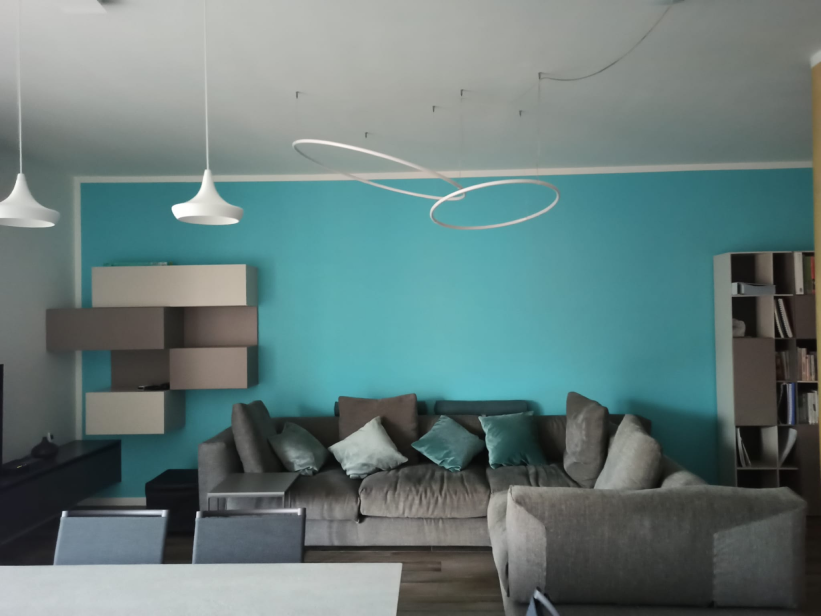 Living room with a blue wall arranged according to feng shui principles by Raffaela Marescalco.