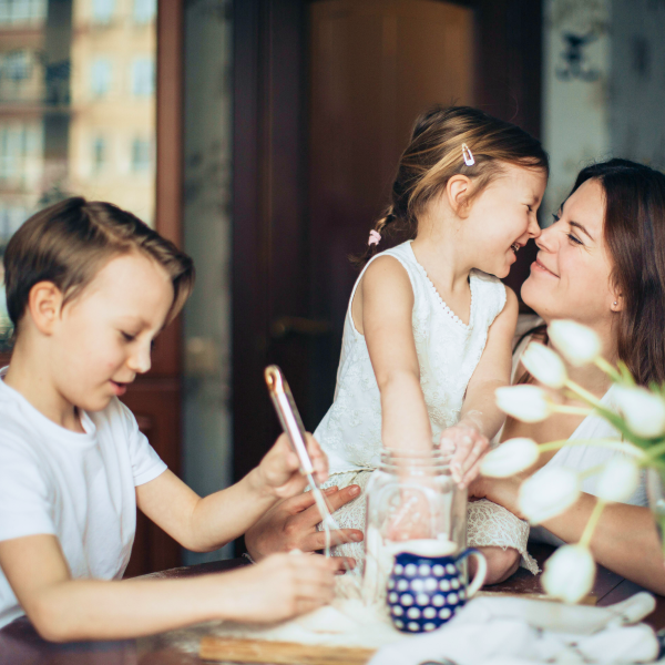 Two children are cooking with their mom.
