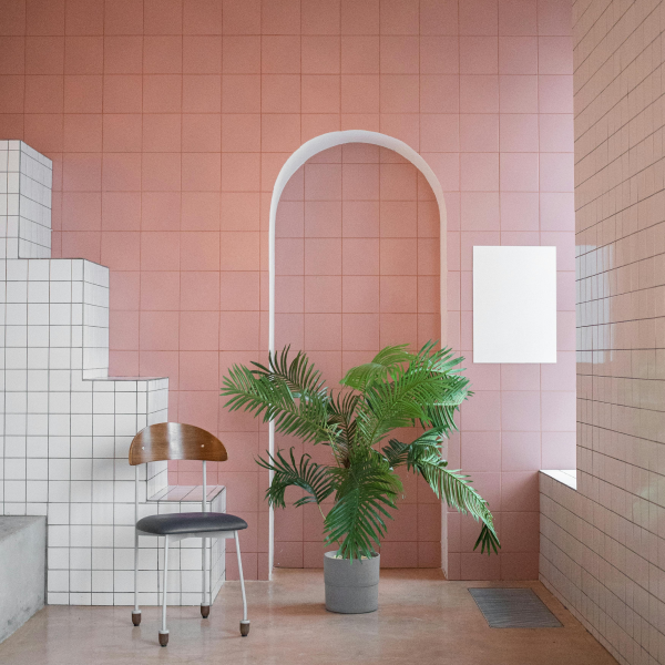 Feng Shui work. A room with a chair and a plant. The walls are tiled in pink and white.