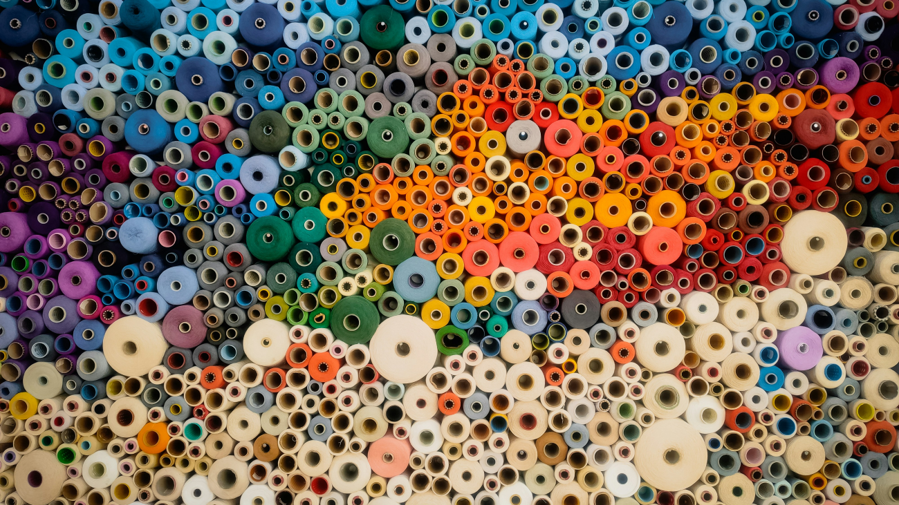 Color analysis. Many fabrics of different colors on carefully organized rolls.