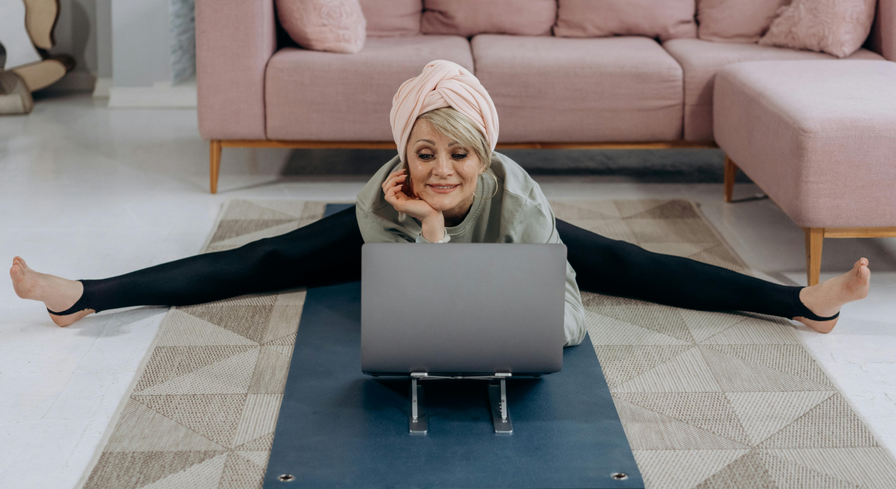 How to Feel Great at Home with Feng Shui: A Smiling Woman Stretches While Working at the Computer.