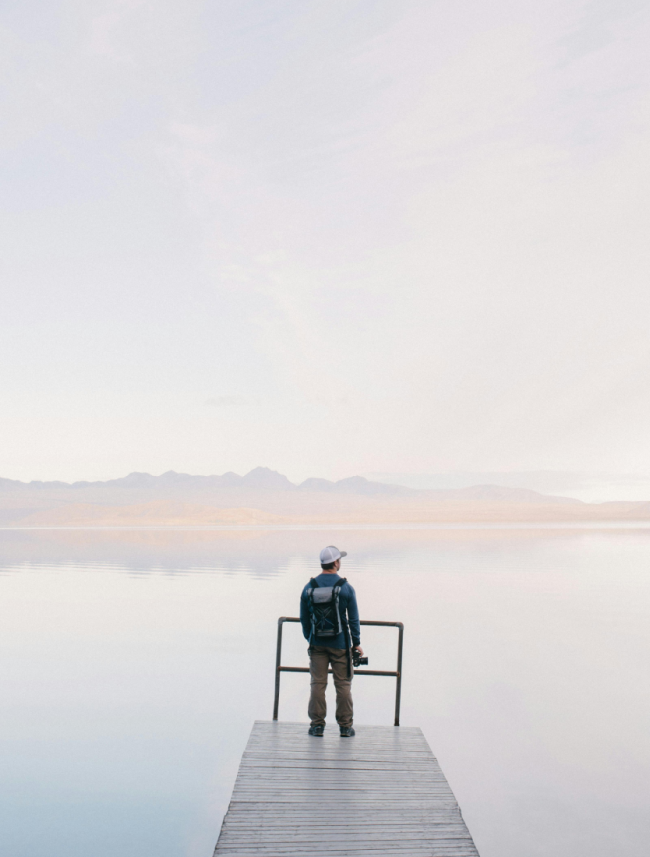 A photographer observes a lake with clear waters.