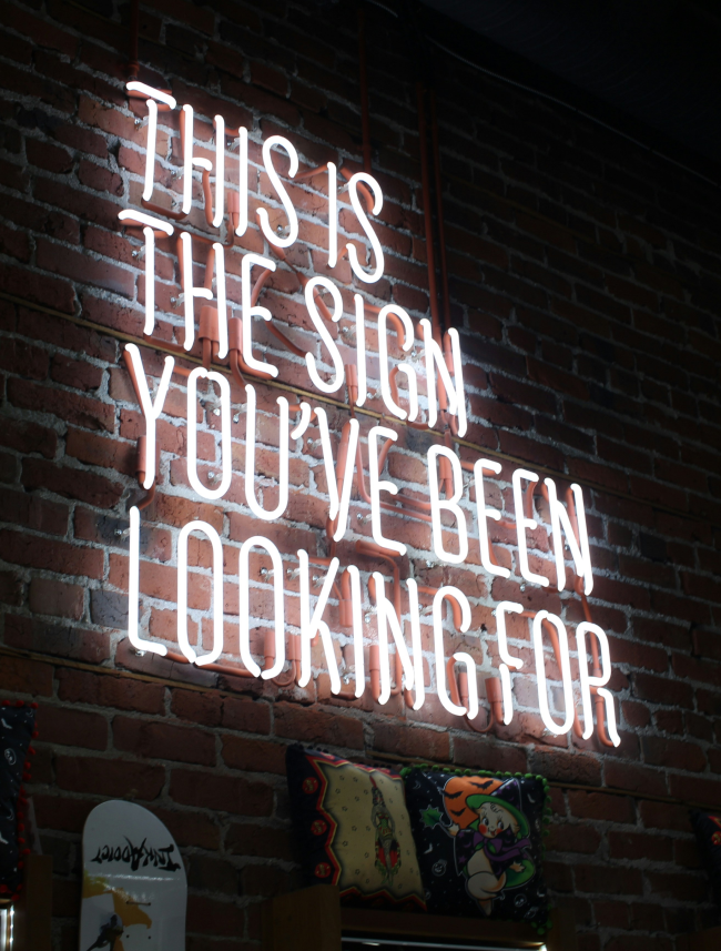 Neon sign displaying the phrase: "This is the sign you've been waiting for. Raffaela Marescalco, a professional Feng Shui consultant will help you.