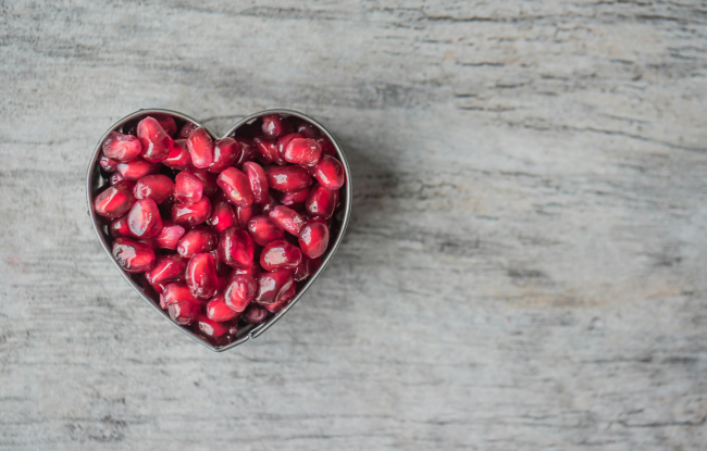 Nutrition. Pomegranate seeds inside a heart-shaped mold.