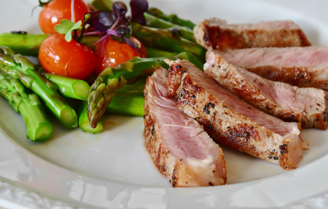 Nutrition. A well-balanced plate with meat, asparagus, and tomatoes.