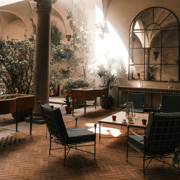 Feng Shui design. A bright and airy living room featuring modern, minimalist furnishings. The room is dominated by a large wall of windows that allows ample natural light to fill the space.