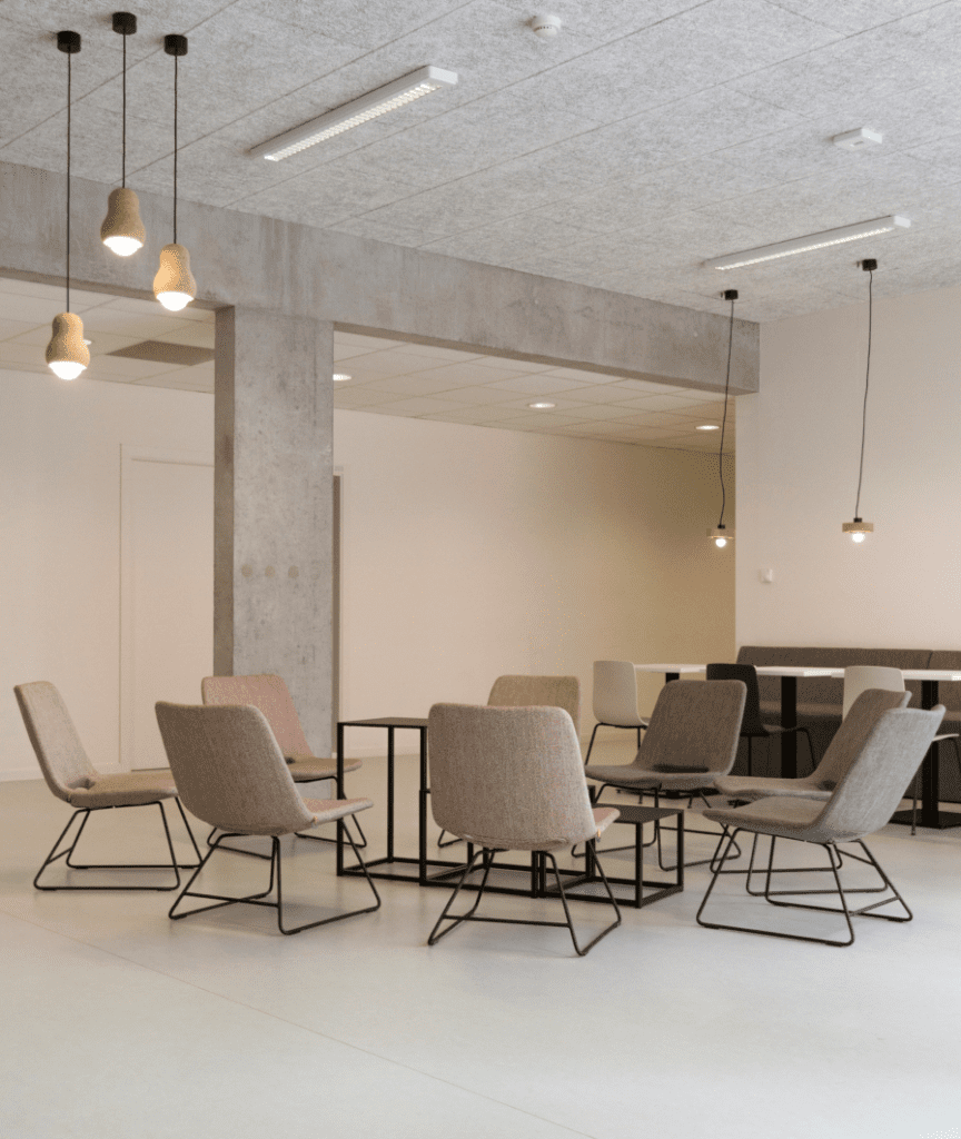 Feng Shui project. Meeting room with gray walls and ceiling lights, featuring taupe designer chairs.